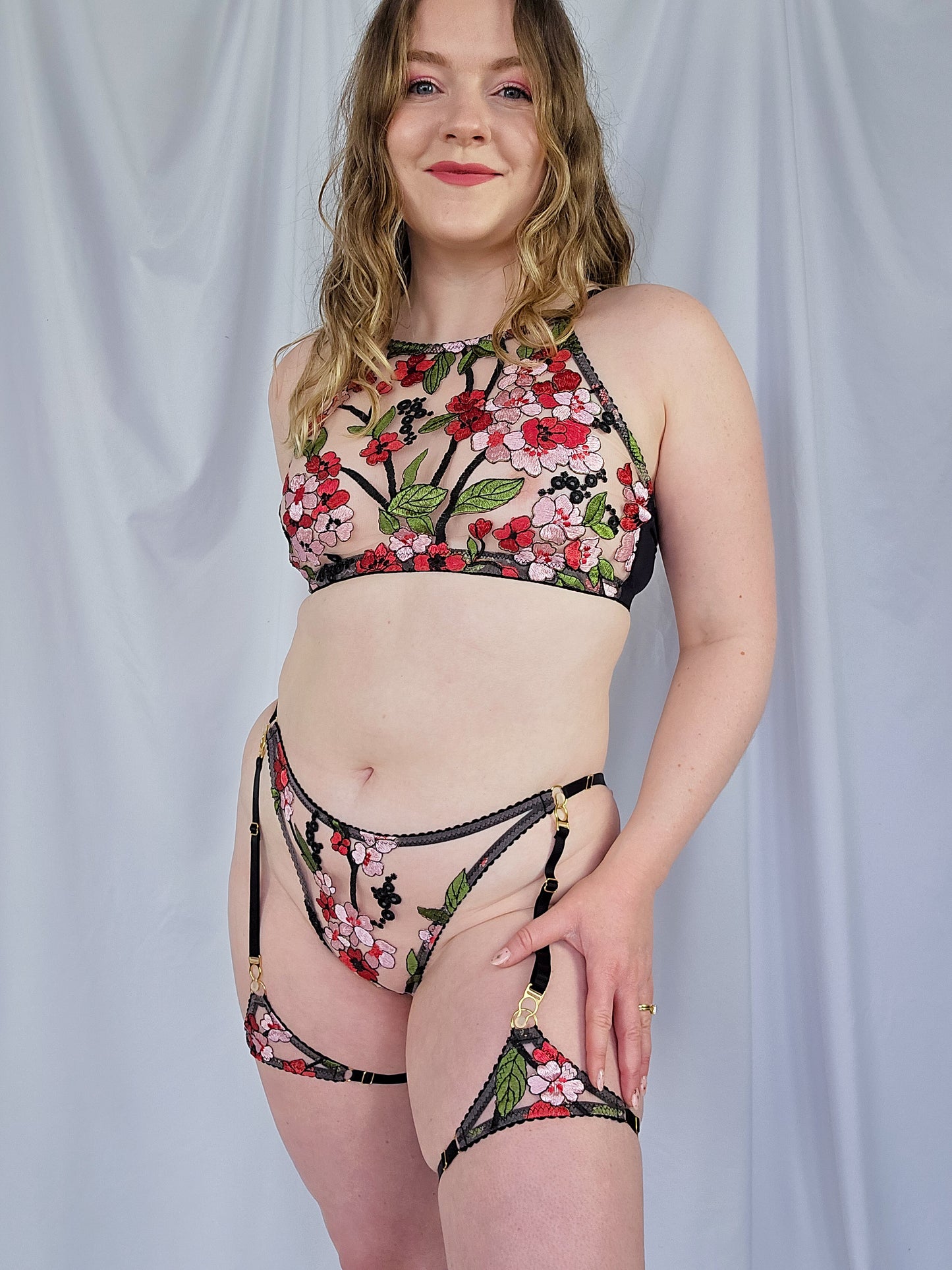 Woman wearing a floral lingerie set against a plain background