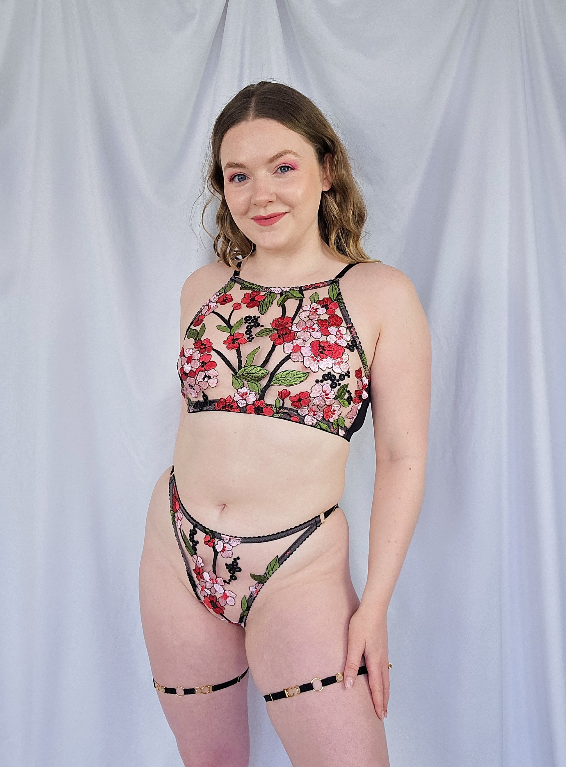 Woman wearing a floral lingerie set against a plain background